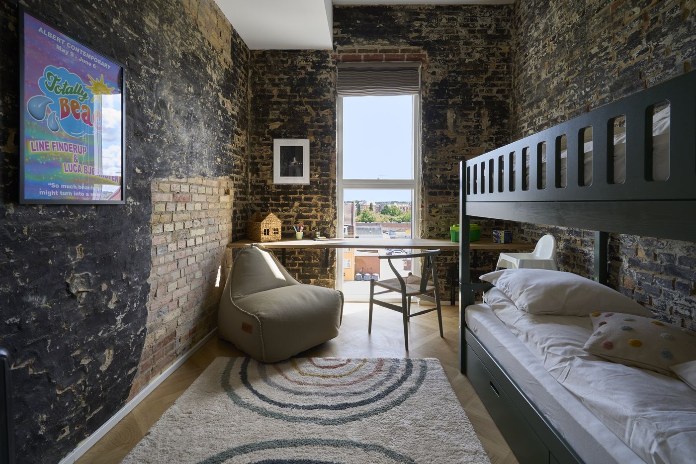 Furnished bedroom with exposed brick wall in an Odense apartment